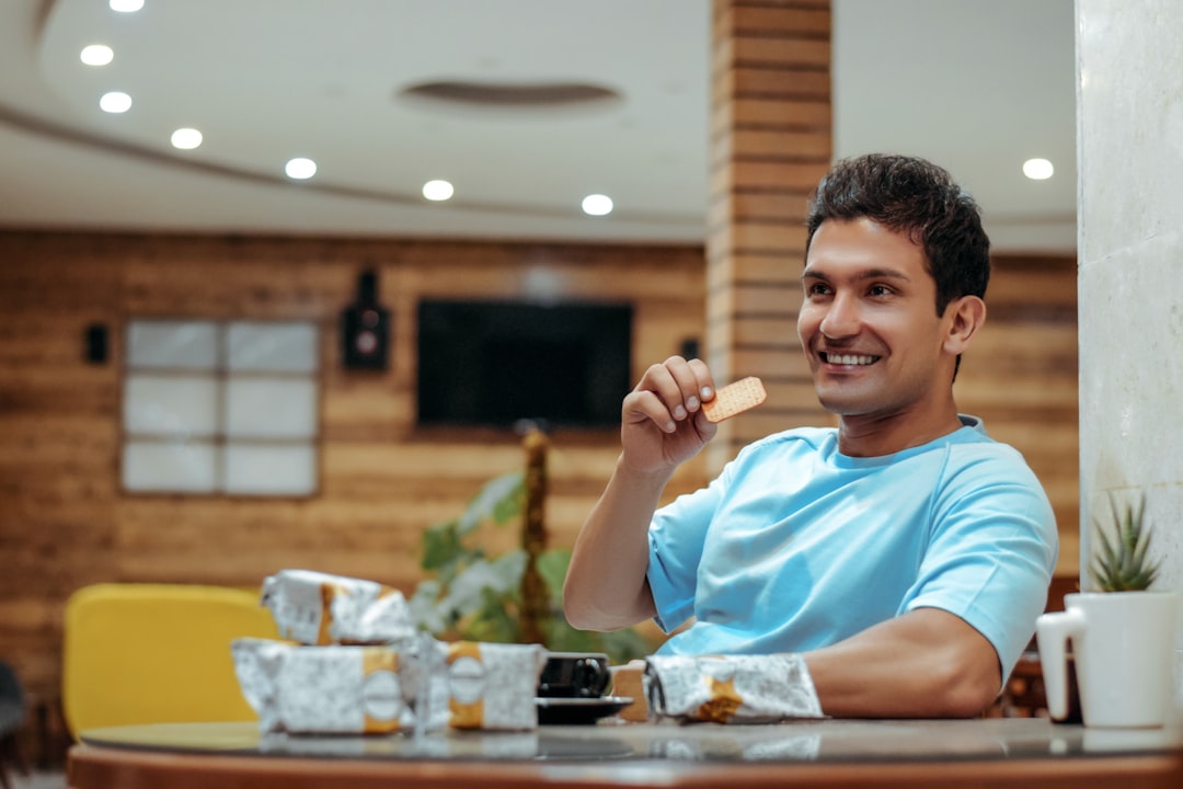 boy in blue crew neck t-shirt sitting on chair