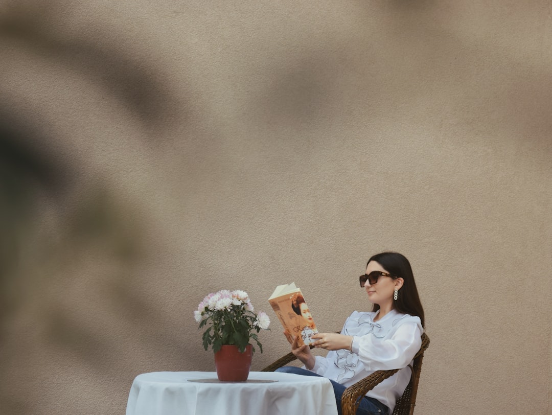 a person sitting at a table reading a book
