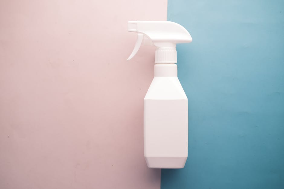 White spray bottle on pink and blue background with copy space, perfect for product mockups.