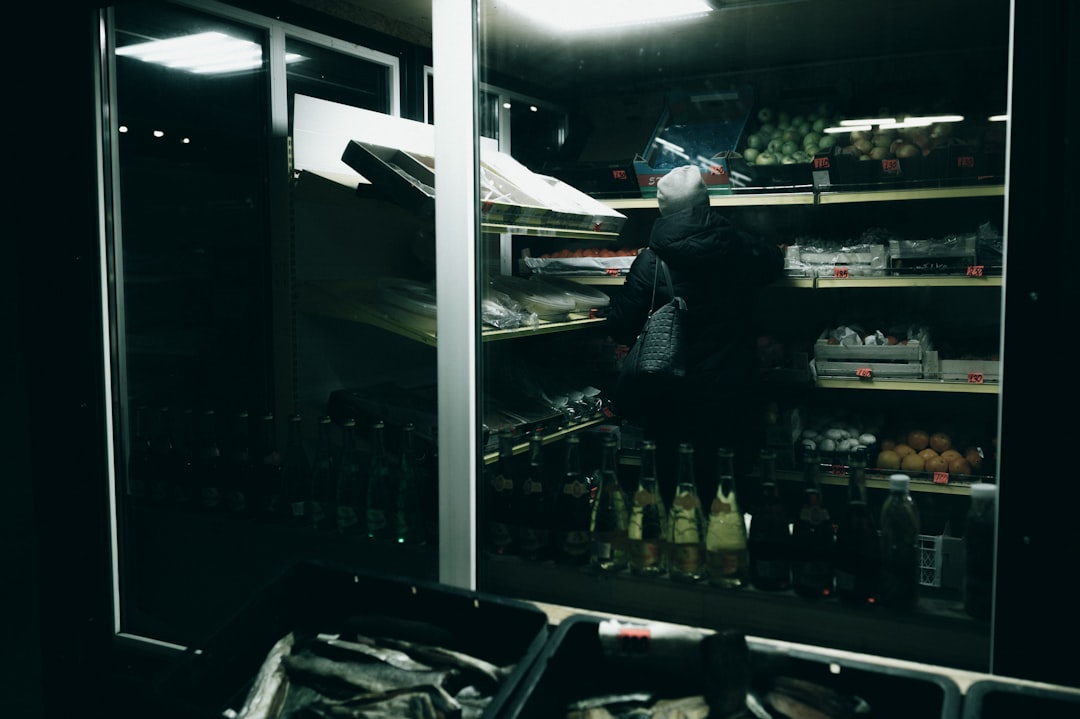 man in black and white striped long sleeve shirt standing in front of glass wall
