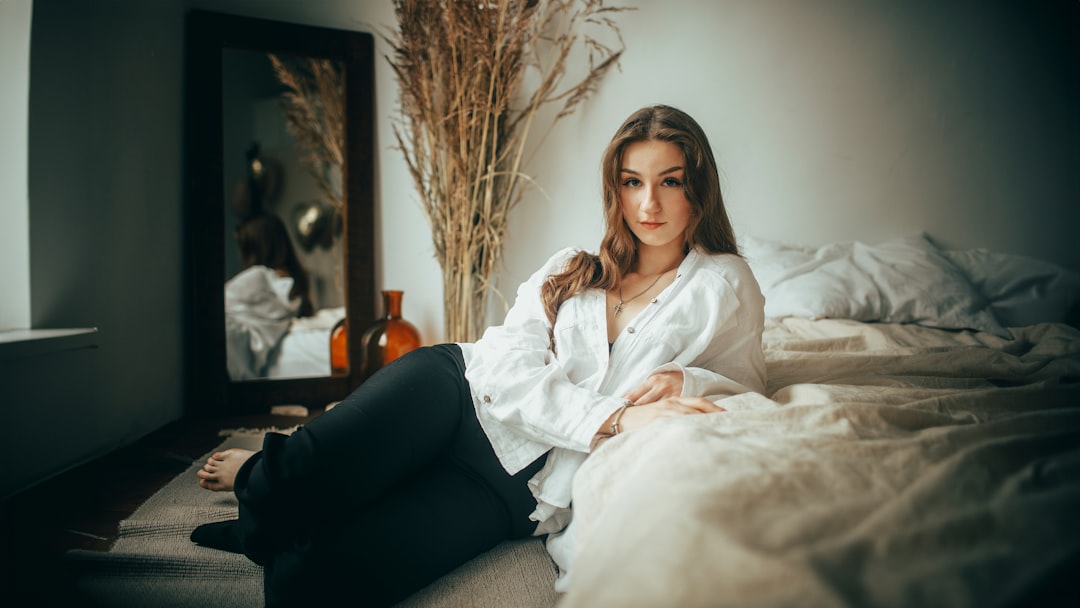 Young woman in white shirt lying on bed