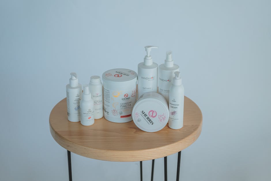 High angle set of assorted skincare products placed on round wooden table on white background in light studio in daytime
