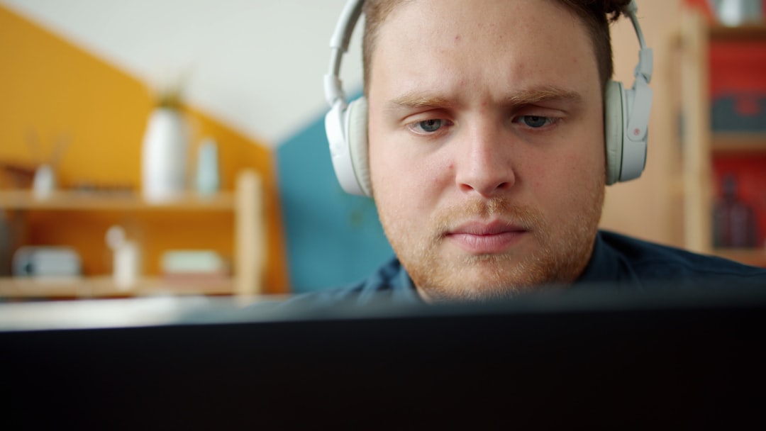 Man wearing headphones looking at computer screen