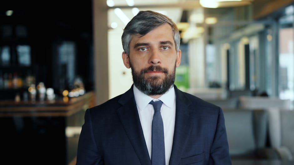 Professional businessman in a suit standing confidently indoors, embodying leadership and success.