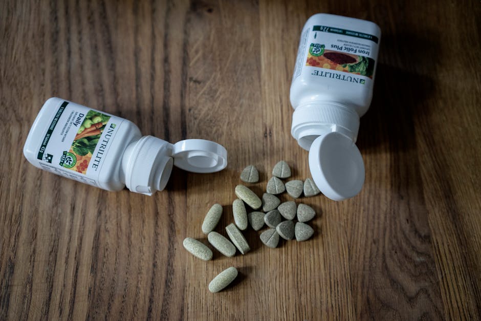 Variety of supplements and vitamin pills with open containers on a wooden surface.