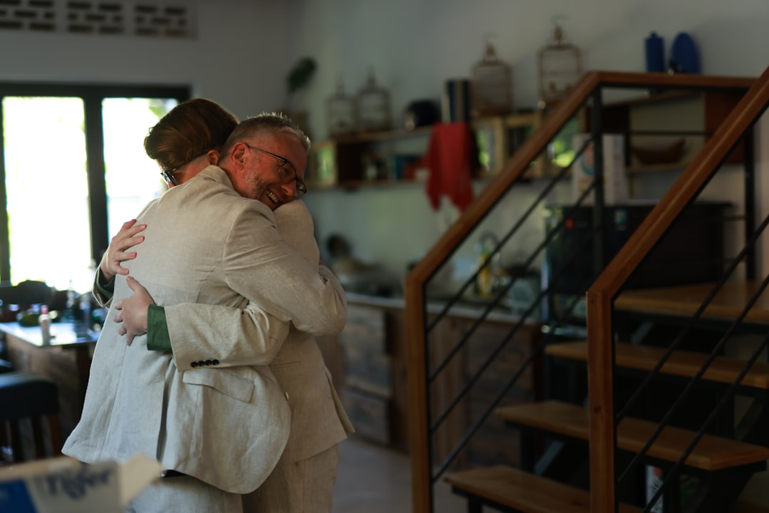 Two people embracing warmly indoors.